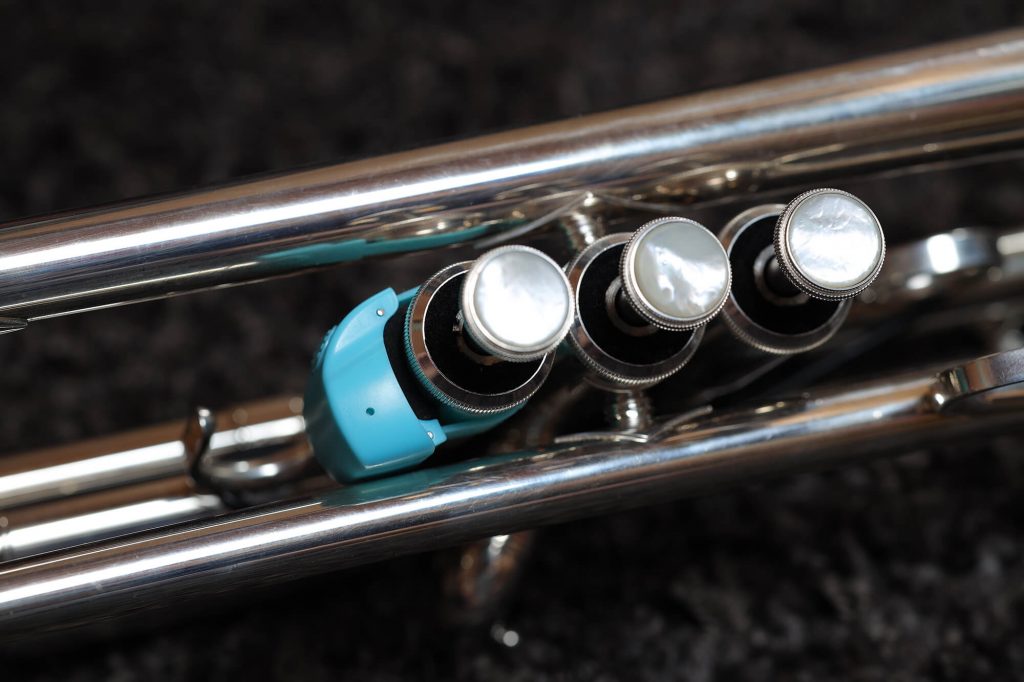 Efun Selfie-Ring R10, angebracht an einer Trompete: Schaumstoffband als Polster zwischen Gehäuseunterseite und Instrument